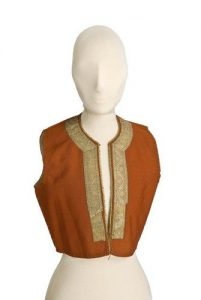 Terracotta cotton waist coat, front opening and round neckline edged with gold braid.