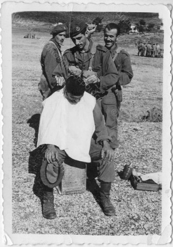 Stavros Teneketzidis cutting a soldier's hair at the military camp