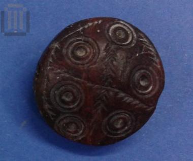 Incised lenticular stone seal
