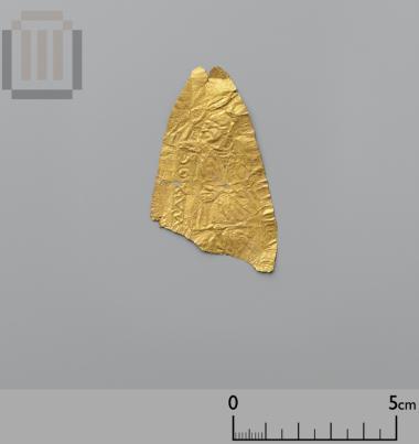 Part of a counterfeit mouthpiece of gold sheet with relief scene and inscription