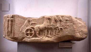 Rectangular sculpture base with a chariot scene.