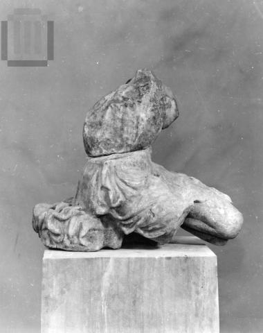 Part of a pediment sculpture  of an amazon, sitting on her feet.