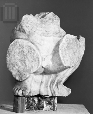Part of a pediment sculpture  of a sitting  male figure.