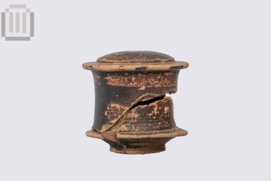 Πήλινη μελαμβαφής κυλινδρική πυξίδα με πώμα, από τα Μάρμαρα