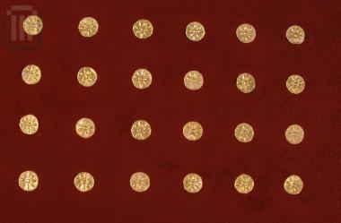 Twenty four small disc-shaped gold sheets with a matrix-hammered relief star from the decoration of a textile