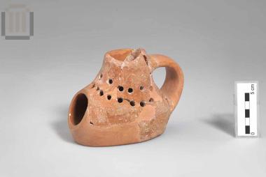 Πήλινο ιδιόμορφο μόνωτο σκεύος με ευρύ στόμιο και οπές στο σώμα (σέσουλα ή θυμιατήριο;)