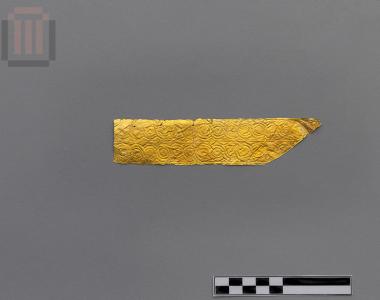 Part of a banded gold sheet with matrix-hammered relief decoration