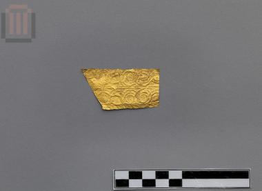 Part of a banded gold sheet with matrix-hammered relief decoration