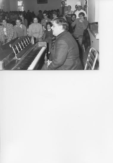 Manos Hadjidakis playing the piano for students and staff, 1973