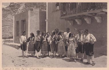 Σκυριανοί και Σκυριανές με παραδοσιακές φορεσιές σε δρόμο, μπροστά από σπίτια της Σκύρου.