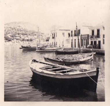 Βάρκες σε μόλο της Ιθάκης, με τον οικισμό στο βάθος.