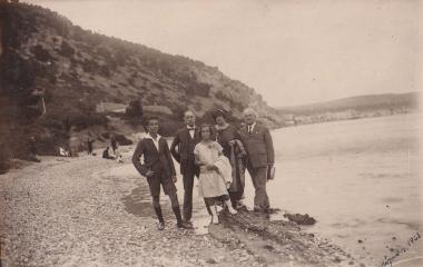 Οικογενειακή φωτογραφία σε παραλία του Λουτρακίου, με τον οικισμό στο βάθος.