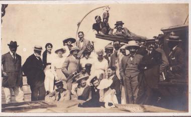 Συντροφιά ανδρών και γυναικών επιβαίνουν σε πλοίο.