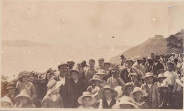 Ενήλικες και παιδιά στα Φηρά της Σαντορίνης (Θήρας), με φόντο την καλντέρα.