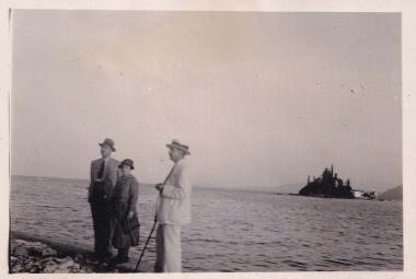 Γυναίκα ανάμεσα σε δύο άνδρες με φόντο το Ποντικονήσι στην Κέρκυρα.