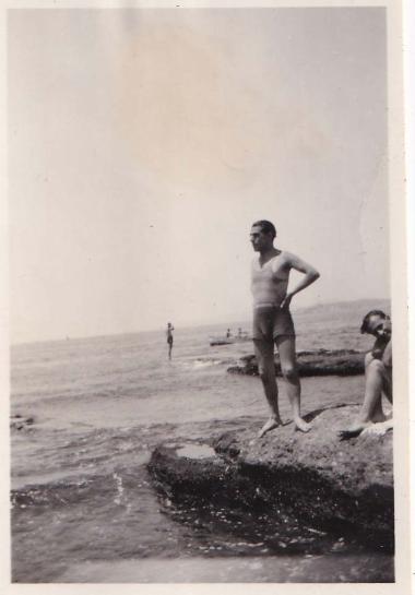 Δύο άνδρες με κολυμβητική περιβολή σε βραχώδη παραλία της Γλυφάδας.