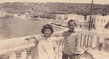 Κορίτσι και αγόρι στέκονται σε εξώστη στη Χώρα της Μυκόνου.