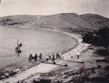 Επισκέπτες και ντόπιοι ψαράδες, με τα δίχτυα τους στη θάλασσα, στην παραλία του οικισμού Κανάκια της Σαλαμίνας.