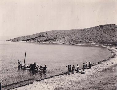 Επισκέπτες και ντόπιοι ψαράδες, με τα δίχτυα τους στη θάλασσα, στην παραλία του οικισμού Κανάκια της Σαλαμίνας.