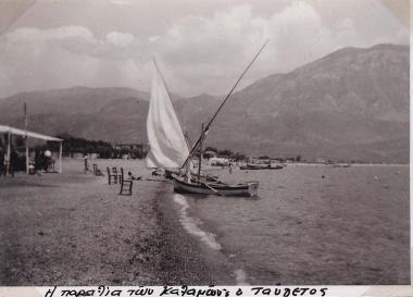 Η παραλία της Καλαμάτας, με λουόμενους και βάρκες, και στο βάθος ο Ταΰγετος.