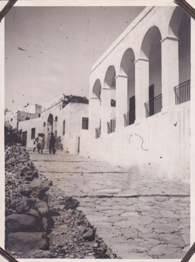 Σχολικό κτήριο πάνω σε κεντρικό, πλακόστρωτο δρόμο στη Μήλο.