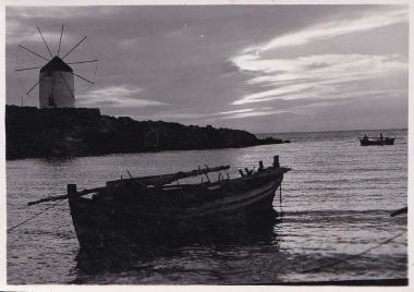 Βάρκα στο νερό μπροστά από ανεμόμυλο.