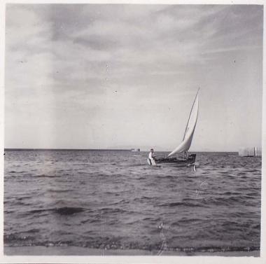 Άνδρας μέσα σε βάρκα με πανί.