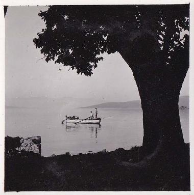 Δύο άνδρες μέσα σε βάρκα, ο ένας από τους οποίους κωπηλατεί.