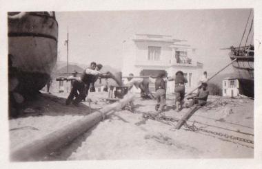 Εργάτες κινούν τροχαλία για να τραβήξουν σκάφος στη στεριά σε καρνάγιο της Καλαμάτας.