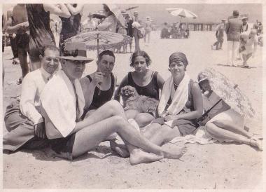 Συντροφιά λουομένων με αλεξήλιο και σκύλο στην παραλία της Γλυφάδας. Φωτογραφία επικολλημένη σε λεύκωμα.