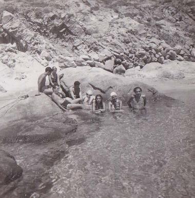 Συντροφιά ανδρών και γυναικών σε παραλία της Δήλου.