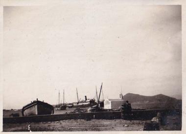 Βάρκες, καΐκι και πλοίο στο λιμάνι της Νάξου. Στο κέντρο διακρίνεται ο ναός της Παναγίας Μυρτιδιώτισσας.