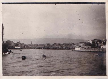 Βάρκες στην είσοδο του λιμανιού των Χανίων και άποψη της παλιάς πόλης από τη θάλασσα∙ στα αριστερά διακρίνεται ο φάρος.