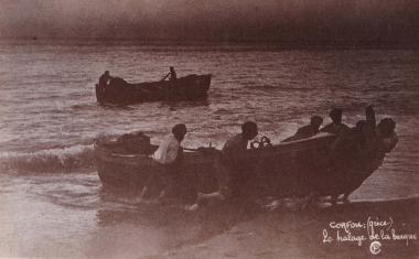 Ψαράδες τραβούν τη βάρκα τους στη στεριά. Πίσως τους, άλλη βάρκα στη θάλασσα.